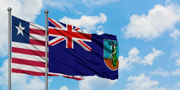利比里亚和蒙特塞拉特国旗在风中飘扬，与白云蓝天相一起。外交概念、国际关系. — 图库照片