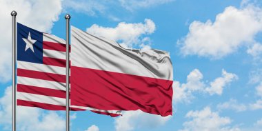 Liberya ve Polonya bayrağı birlikte beyaz bulutlu mavi gökyüzüne karşı rüzgarda sallayarak. Diplomasi kavramı, uluslararası ilişkiler.