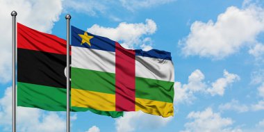 Libya ve Orta Afrika Cumhuriyeti bayrağı birlikte beyaz bulutlu mavi gökyüzüne karşı rüzgarsal sallayarak. Diplomasi kavramı, uluslararası ilişkiler.