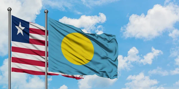 Bandera de Liberia y Palau ondeando en el viento contra el cielo azul nublado blanco juntos. Concepto diplomático, relaciones internacionales . — Foto de Stock