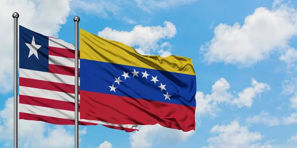 Ліберії і Венесуели прапор розмахуючи в вітру проти білого хмарного синього неба разом. Концепція дипломатії, міжнародні відносини. — стокове фото