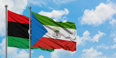 Libya ve Ekvator Ginesi bayrağı birlikte beyaz bulutlu mavi gökyüzüne karşı rüzgarda sallayarak. Diplomasi kavramı, uluslararası ilişkiler.