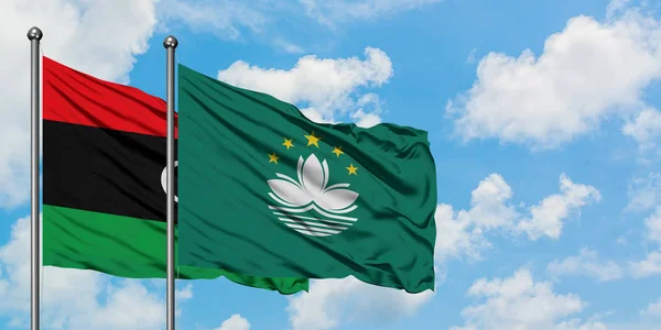 Bandera de Libia y Macao ondeando en el viento contra el cielo azul nublado blanco juntos. Concepto diplomático, relaciones internacionales . — Foto de Stock