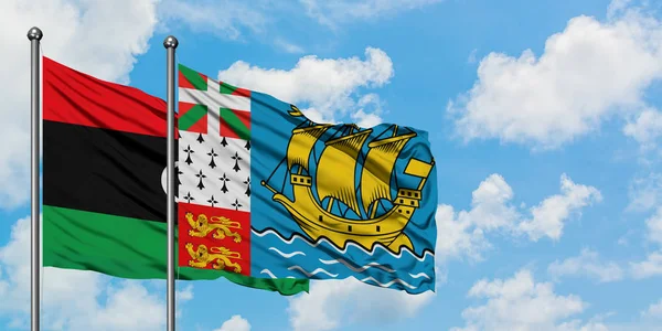 Libya and Saint Pierre And Miquelon flag waving in the wind against white cloudy blue sky together. Diplomacy concept, international relations. — Stock Photo, Image