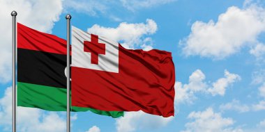 Libya ve Tonga bayrağı birlikte beyaz bulutlu mavi gökyüzüne karşı rüzgarsal sallayarak. Diplomasi kavramı, uluslararası ilişkiler.