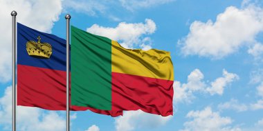 Liechtenstein ve Benin bayrağı birlikte beyaz bulutlu mavi gökyüzüne karşı rüzgarda sallayarak. Diplomasi kavramı, uluslararası ilişkiler.