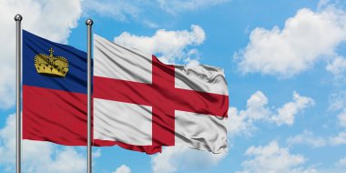 Liechtenstein ve İngiltere bayrağı birlikte beyaz bulutlu mavi gökyüzüne karşı rüzgarda sallayarak. Diplomasi kavramı, uluslararası ilişkiler.