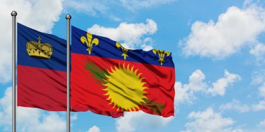Liechtenstein ve Guadeloupe bayrağı birlikte beyaz bulutlu mavi gökyüzüne karşı rüzgarda sallayarak. Diplomasi kavramı, uluslararası ilişkiler.
