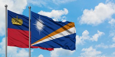 Liechtenstein ve Marshall Adaları bayrağı birlikte beyaz bulutlu mavi gökyüzüne karşı rüzgarda sallayarak. Diplomasi kavramı, uluslararası ilişkiler.