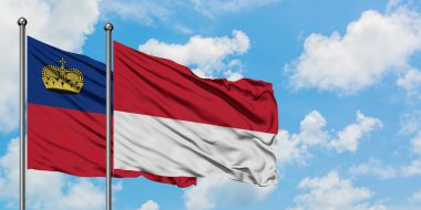 Liechtenstein ve Monako bayrağı birlikte beyaz bulutlu mavi gökyüzüne karşı rüzgarda sallayarak. Diplomasi kavramı, uluslararası ilişkiler.