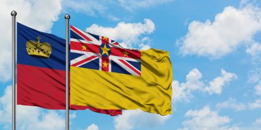 Liechtenstein ve Niue bayrağı birlikte beyaz bulutlu mavi gökyüzüne karşı rüzgarda sallayarak. Diplomasi kavramı, uluslararası ilişkiler.