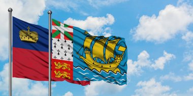 Liechtenstein ve Saint Pierre ve Miquelon bayrağı birlikte beyaz bulutlu mavi gökyüzüne karşı rüzgarda sallayarak. Diplomasi kavramı, uluslararası ilişkiler.