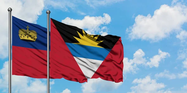 Liechtenstein ve Antigua ve Barbuda bayrağı birlikte beyaz bulutlu mavi gökyüzüne karşı rüzgarda sallayarak. Diplomasi kavramı, uluslararası ilişkiler. — Stok fotoğraf