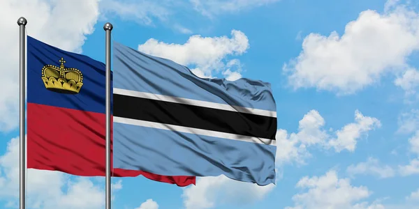 Liechtenstein e Botswana sventolano insieme la bandiera contro il bianco cielo azzurro nuvoloso. Concetto di diplomazia, relazioni internazionali . — Foto Stock