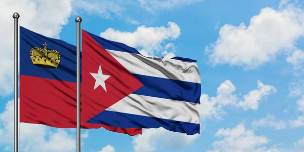 Bandera de Liechtenstein y Cuba ondeando en el viento contra el cielo azul nublado blanco juntos. Concepto diplomático, relaciones internacionales . —  Fotos de Stock