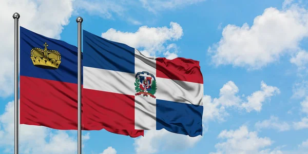 Liechtenstein e a bandeira da República Dominicana agitando no vento contra o céu azul nublado branco juntos. Conceito de diplomacia, relações internacionais . — Fotografia de Stock