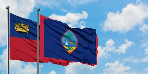 Liechtenstein and Guam flag waving in the wind against white cloudy blue sky together. Diplomacy concept, international relations. — Stock Photo, Image