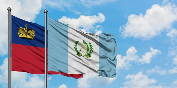 Bandera de Liechtenstein y Guatemala ondeando en el viento contra el cielo azul nublado blanco juntos. Concepto diplomático, relaciones internacionales . — Foto de Stock