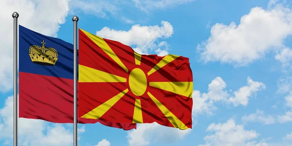 Liechtenstein e Macedônia acenando ao vento contra o céu azul nublado branco juntos. Conceito de diplomacia, relações internacionais . — Fotografia de Stock