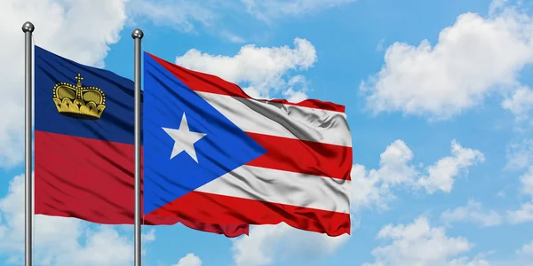 Liechtenstein e a bandeira de Porto Rico agitando no vento contra o céu azul nublado branco juntos. Conceito de diplomacia, relações internacionais . — Fotografia de Stock