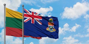 Litvanya ve Cayman Adaları bayrağı birlikte beyaz bulutlu mavi gökyüzüne karşı rüzgarda sallayarak. Diplomasi kavramı, uluslararası ilişkiler.