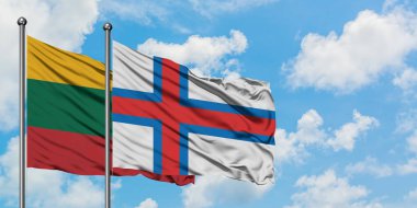 Litvanya ve Faroe Adaları bayrağı birlikte beyaz bulutlu mavi gökyüzüne karşı rüzgarda sallayarak. Diplomasi kavramı, uluslararası ilişkiler.