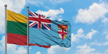 Litvanya ve Fiji bayrağı birlikte beyaz bulutlu mavi gökyüzüne karşı rüzgarda sallayarak. Diplomasi kavramı, uluslararası ilişkiler.