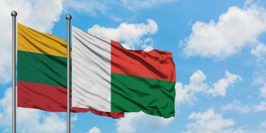 Litvanya ve Madagaskar bayrağı birlikte beyaz bulutlu mavi gökyüzüne karşı rüzgarda sallayarak. Diplomasi kavramı, uluslararası ilişkiler.