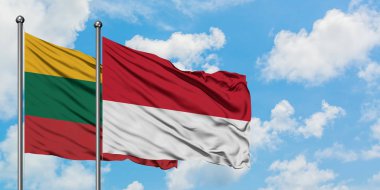 Litvanya ve Monako bayrağı birlikte beyaz bulutlu mavi gökyüzüne karşı rüzgarda sallayarak. Diplomasi kavramı, uluslararası ilişkiler.