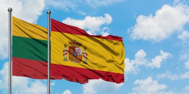 Litvanya ve İspanya bayrağı birlikte beyaz bulutlu mavi gökyüzüne karşı rüzgarda sallayarak. Diplomasi kavramı, uluslararası ilişkiler.