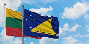 Litvanya ve Tokelau bayrağı birlikte beyaz bulutlu mavi gökyüzüne karşı rüzgarda sallayarak. Diplomasi kavramı, uluslararası ilişkiler.