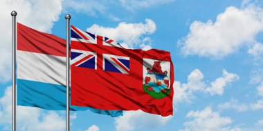 Lüksemburg ve Bermuda bayrağı birlikte beyaz bulutlu mavi gökyüzüne karşı rüzgarda sallayarak. Diplomasi kavramı, uluslararası ilişkiler.