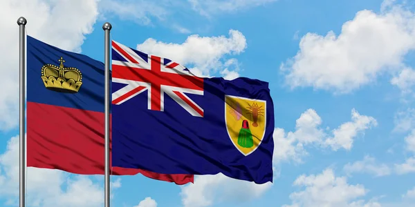 Bandera de Liechtenstein y las Islas Turcas y Caicos ondeando en el viento contra el cielo azul nublado blanco juntos. Concepto diplomático, relaciones internacionales . — Foto de Stock
