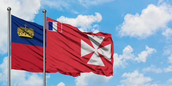 Bandera de Liechtenstein y Wallis And Futuna ondeando en el viento contra el cielo azul nublado blanco juntos. Concepto diplomático, relaciones internacionales . — Foto de Stock