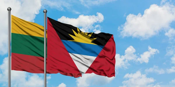 Lithuania and Antigua and Barbuda flag waving in the wind against white cloudy blue sky together. Diplomacy concept, international relations. — Stock Photo, Image