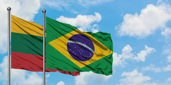 Bandera de Lituania y Brasil ondeando en el viento contra el cielo azul nublado blanco juntos. Concepto diplomático, relaciones internacionales . — Foto de Stock