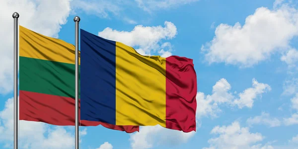 Bandera de Lituania y Chad ondeando en el viento contra el cielo azul nublado blanco juntos. Concepto diplomático, relaciones internacionales . — Foto de Stock