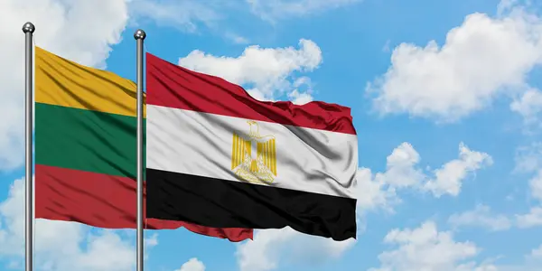 Bandera de Lituania y Egipto ondeando en el viento contra el cielo azul nublado blanco juntos. Concepto diplomático, relaciones internacionales . — Foto de Stock