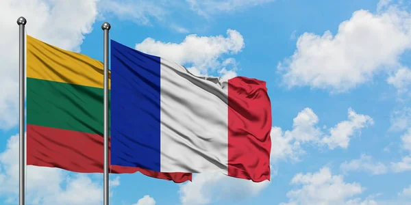 Bandera de Lituania y Francia ondeando en el viento contra el cielo azul nublado blanco juntos. Concepto diplomático, relaciones internacionales . — Foto de Stock
