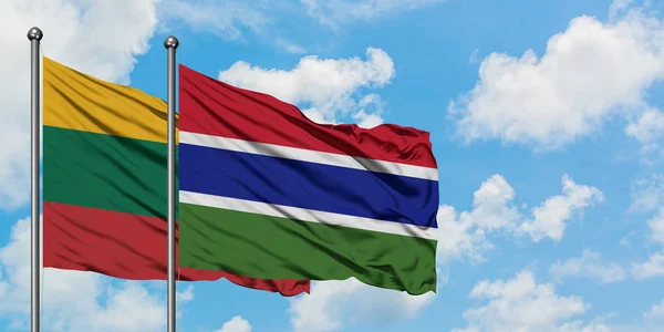 Stock image Lithuania and Gambia flag waving in the wind against white cloudy blue sky together. Diplomacy concept, international relations.