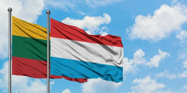 Bandera de Lituania y Luxemburgo ondeando en el viento contra el cielo azul nublado blanco juntos. Concepto diplomático, relaciones internacionales . —  Fotos de Stock