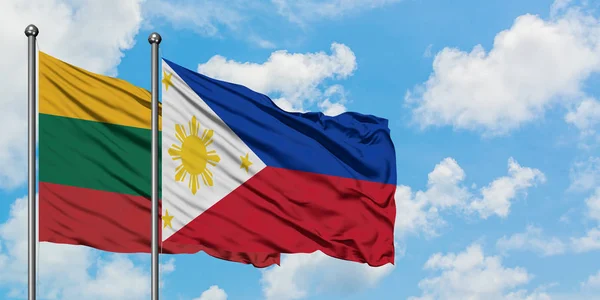 Bandera de Lituania y Filipinas ondeando en el viento contra el cielo azul nublado blanco juntos. Concepto diplomático, relaciones internacionales . — Foto de Stock