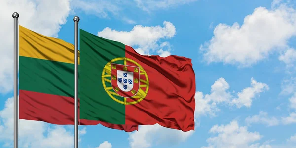 Litwa i Portugalia flaga machając w wiatr przed białym zachmurzone błękitne niebo razem. Koncepcja dyplomacji, stosunki międzynarodowe. — Zdjęcie stockowe