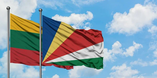 Bandera de Lituania y Seychelles ondeando en el viento contra el cielo azul nublado blanco juntos. Concepto diplomático, relaciones internacionales . — Foto de Stock
