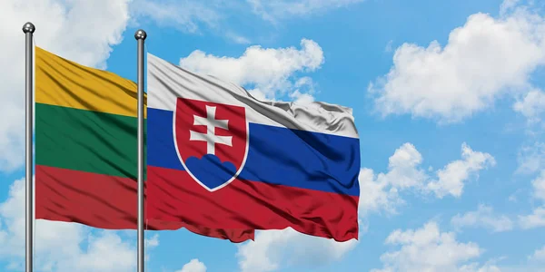 Drapeau de la Lituanie et de la Slovaquie agitant dans le vent contre ciel bleu nuageux blanc ensemble. Concept de diplomatie, relations internationales . — Photo