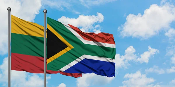Litva a Jihoafrická vlajka mávajících větrem proti bíle zatažené modré obloze. Diplomacie, mezinárodní vztahy. — Stock fotografie