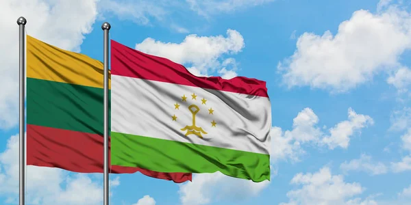 Bandera de Lituania y Tayikistán ondeando en el viento contra el cielo azul nublado blanco juntos. Concepto diplomático, relaciones internacionales . — Foto de Stock