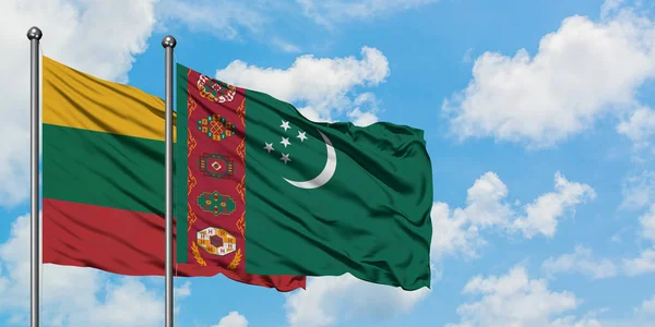 Bandera de Lituania y Turkmenistán ondeando en el viento contra el cielo azul nublado blanco juntos. Concepto diplomático, relaciones internacionales . — Foto de Stock