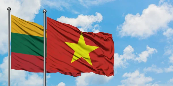 Litauen og Vietnam flag vinker i vinden mod hvid overskyet blå himmel sammen. Diplomati koncept, internationale relationer . - Stock-foto