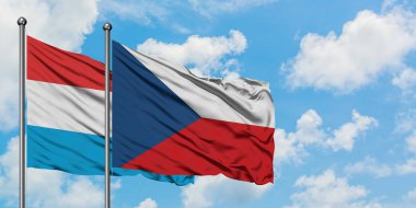 Lüksemburg ve Çek Cumhuriyeti bayrağı birlikte beyaz bulutlu mavi gökyüzüne karşı rüzgarda sallayarak. Diplomasi kavramı, uluslararası ilişkiler.